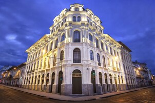 Un edificio histórico con fachada simétrica, ventanas amplias y una entrada central.