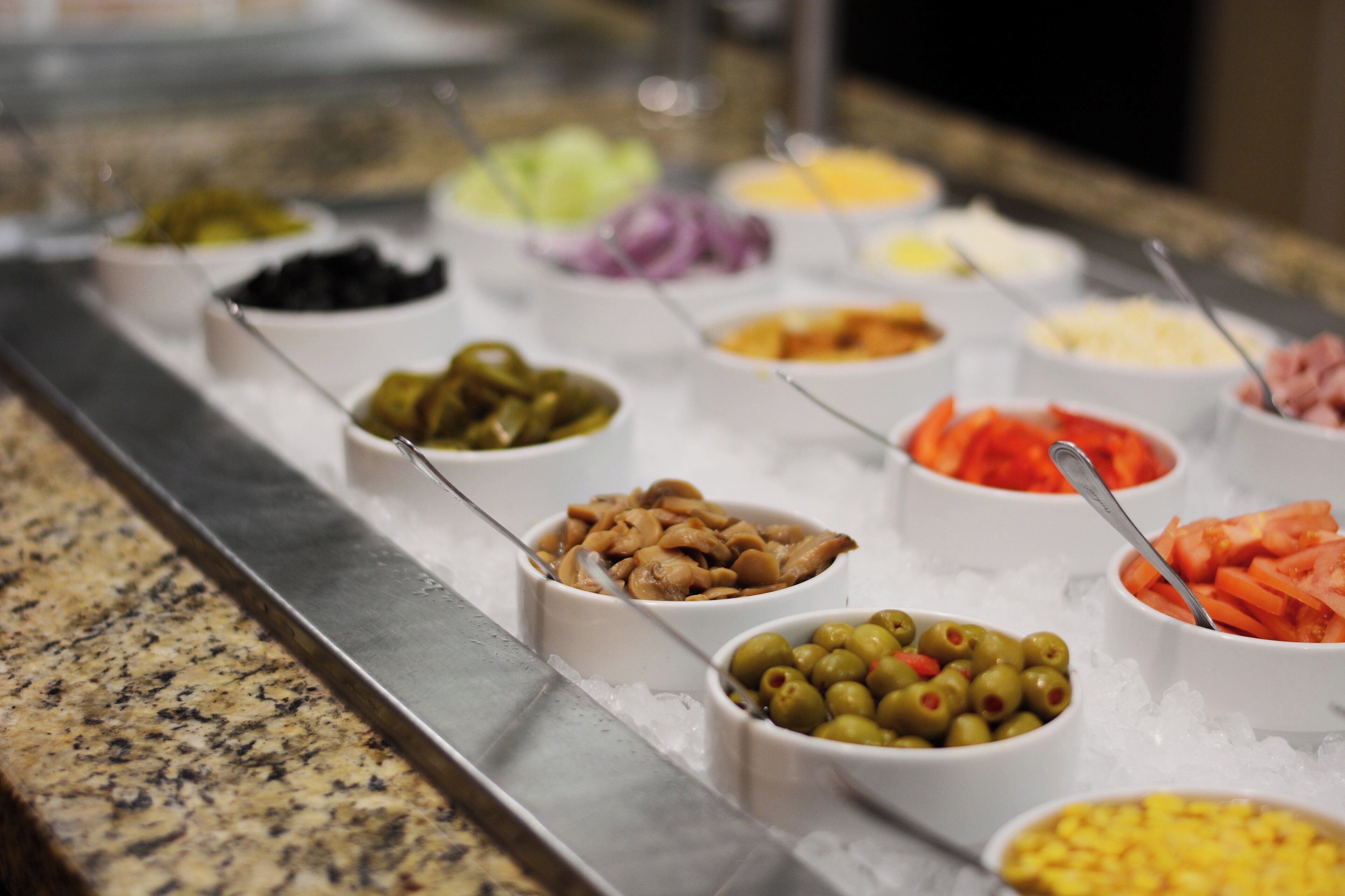 A buffet with various food items in bowls on a tray.