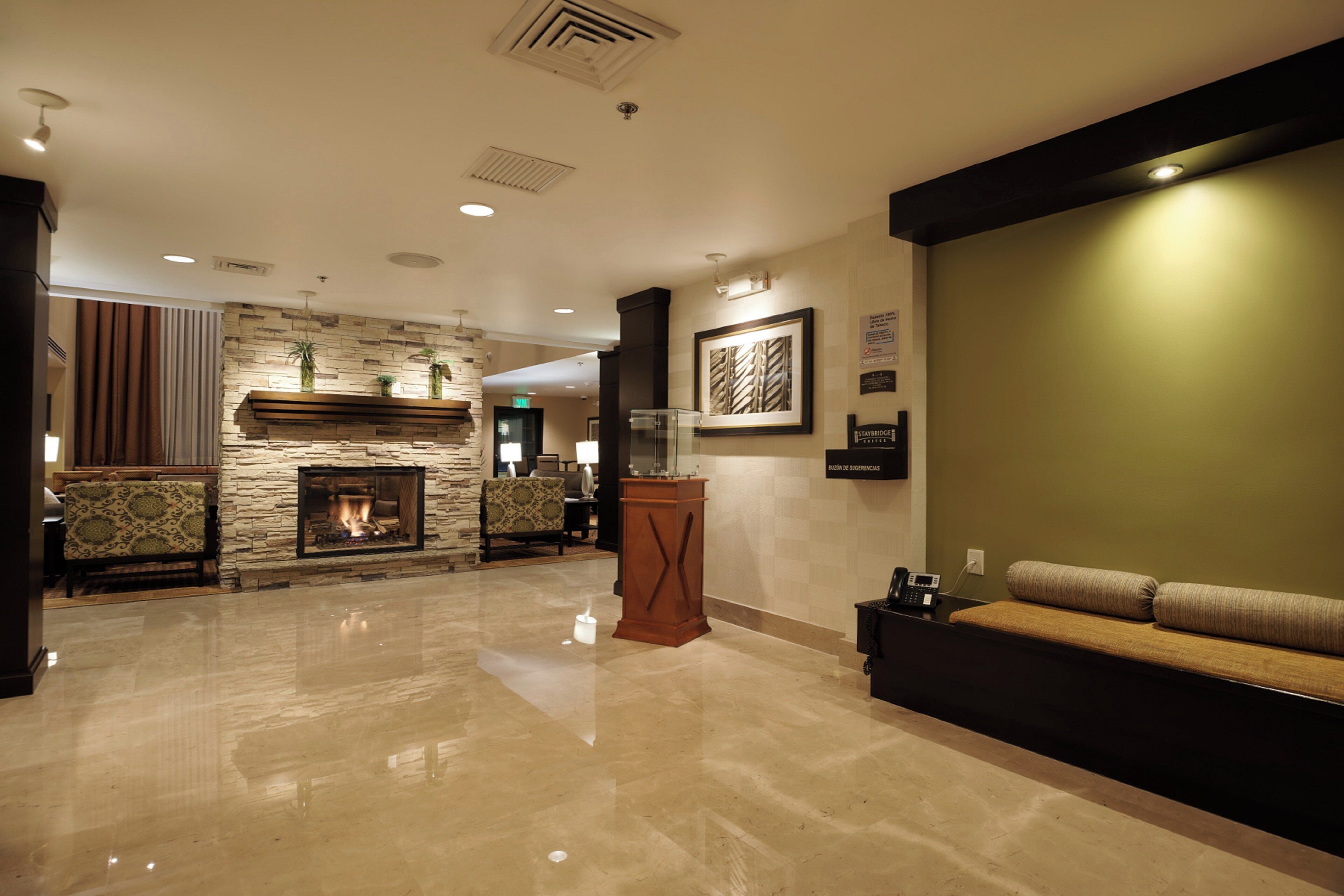 A spacious lobby with a stone fireplace, a reception desk, and a seating area.