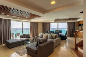 Una sala de estar moderna con un sofá, una mesa de centro y vista al mar.