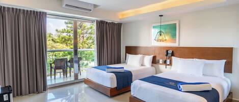 A hotel room with two beds, a balcony, and a painting on the wall.