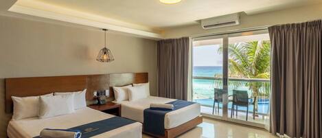 A hotel room with two beds, a nightstand, a lamp, and a view of the ocean.