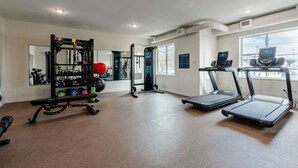 A gym with treadmills, a bench press, and a squat rack. - WaterWalk Extended Stay by Wyndham Wichita (Wichita)