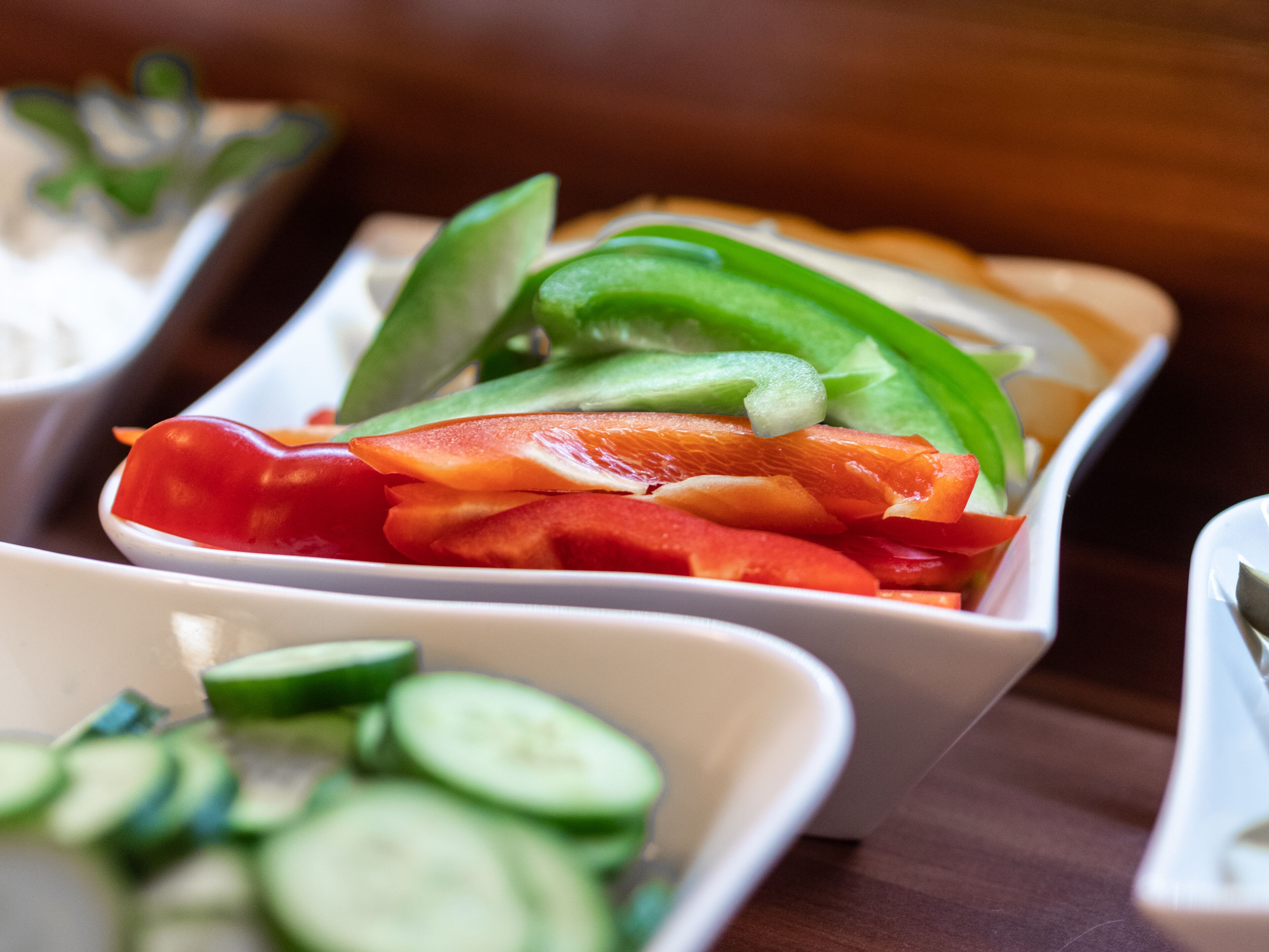 A close-up of a dish with sliced vegetables and fish.