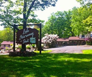 A sign for Lake Harmony Inn with a stone wall and trees in the background. - Lake Harmony Inn (Lake Harmony)