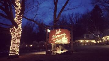 A sign for 'Lake Harmony Inn' with a rustic wooden structure and a tree decorated with lights.