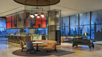 A modern bar area with a pool table, seating, and a bar counter.