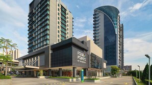 Un hotel moderno con un llamativo letrero de 'Four Points by Sheraton', que presenta una fachada elegante y amplias ventanas.