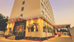 A modern hotel with a prominent entrance, multiple floors, and a covered outdoor area with potted plants. - Hotel Marigold Jaipur (Jaipur)