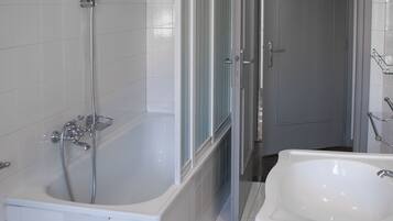 A bathroom with a bathtub, a shower, and a sink.