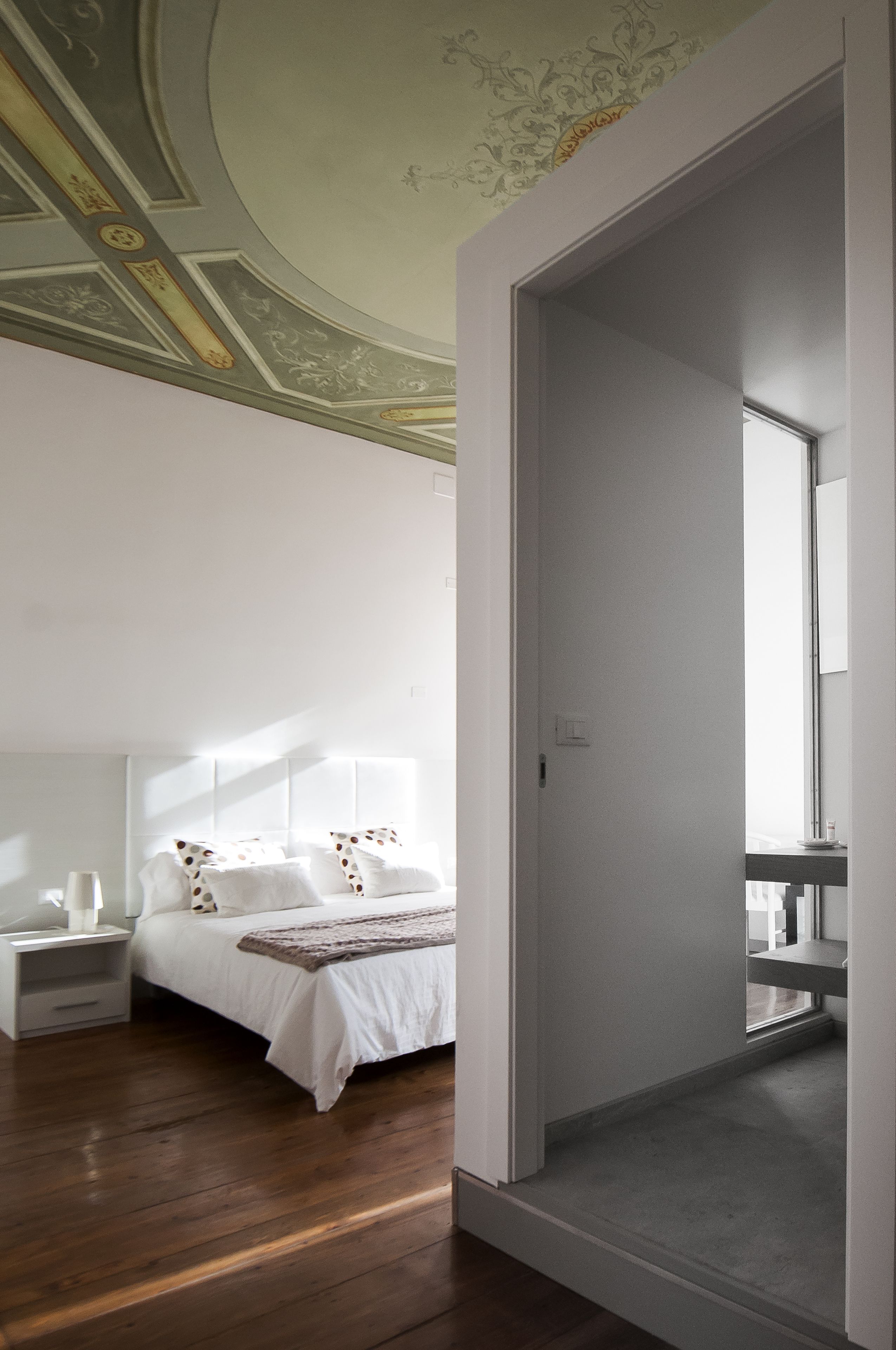 A bedroom with a bed, nightstands, and a mirror.
