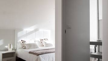 A bedroom with a bed, nightstands, and a mirror.