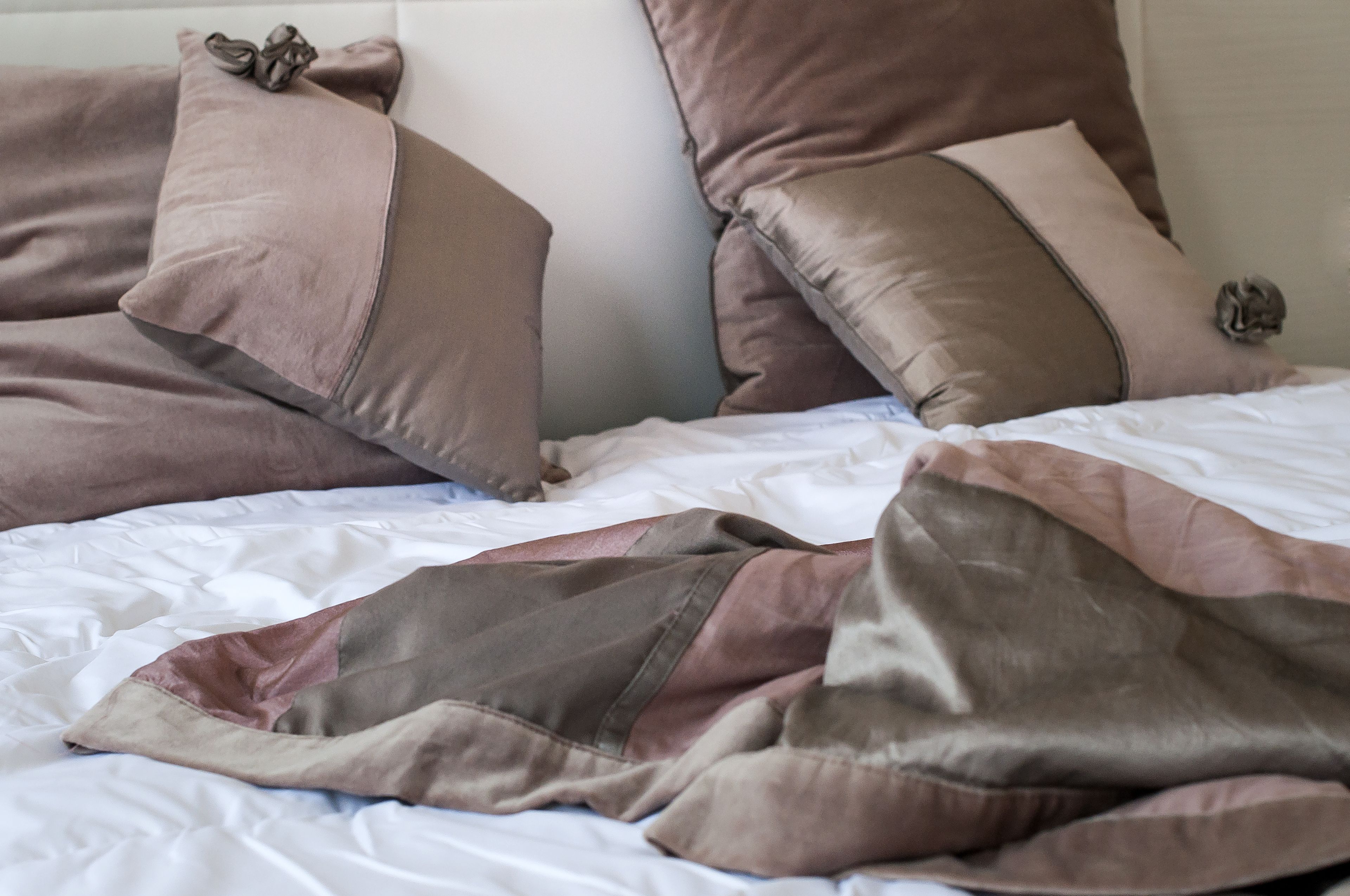 Un lit avec plusieurs oreillers et une couverture.