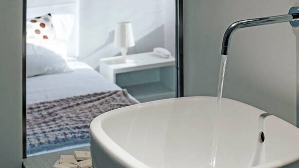 A bathroom with a white sink and a running faucet. - B&B Scrovegni (Padova)