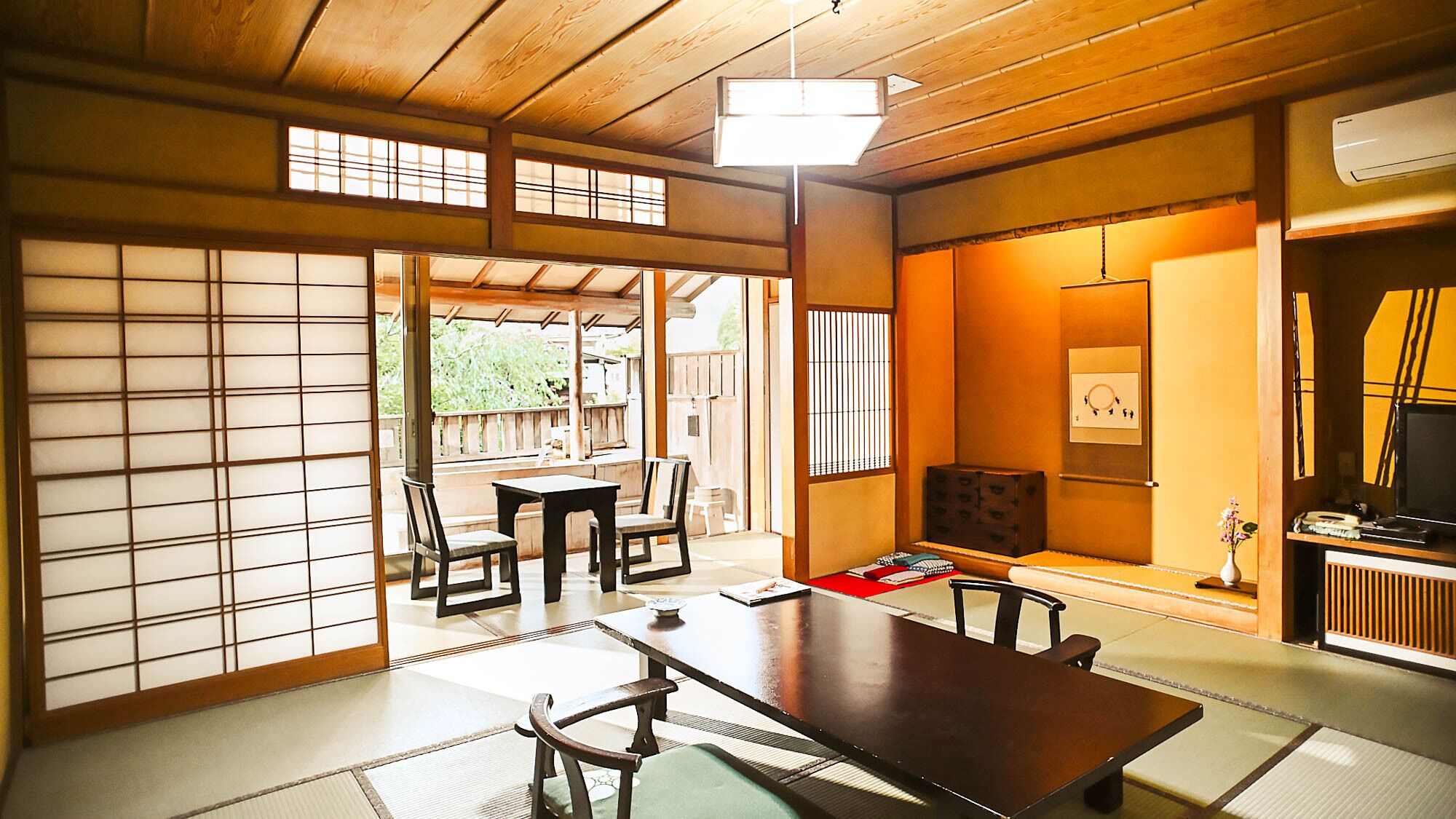 Una habitación japonesa tradicional con suelo de tatami, una mesa baja y puertas correderas.