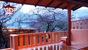 A wooden deck with a hot tub, a wooden bench, and a lantern. - Shin Kado Ya (Atami)