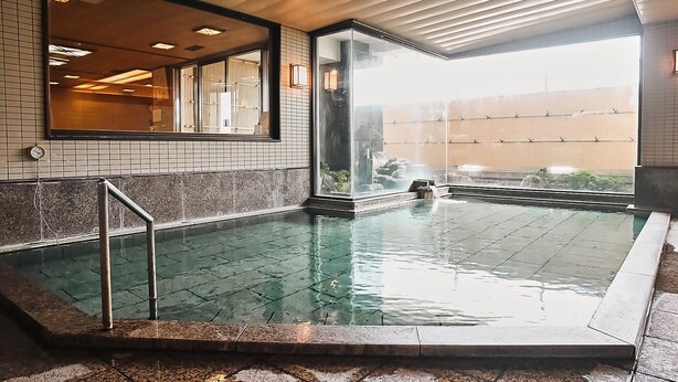A pool area with a tiled floor, a metal handrail, and a view of the outside through a glass door. - Shin Kado Ya (Atami)