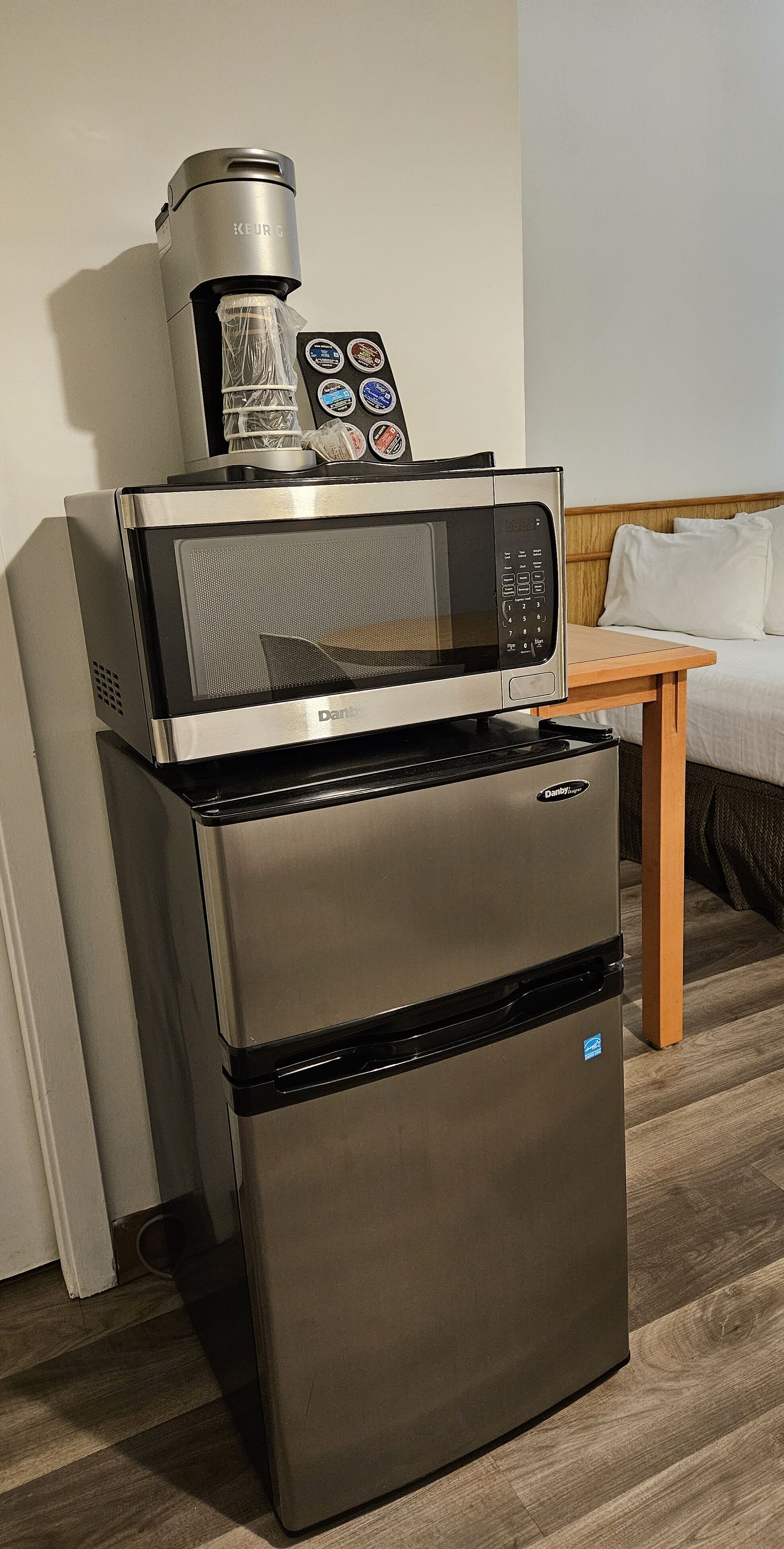 A compact kitchenette with a microwave, coffee maker, and refrigerator.