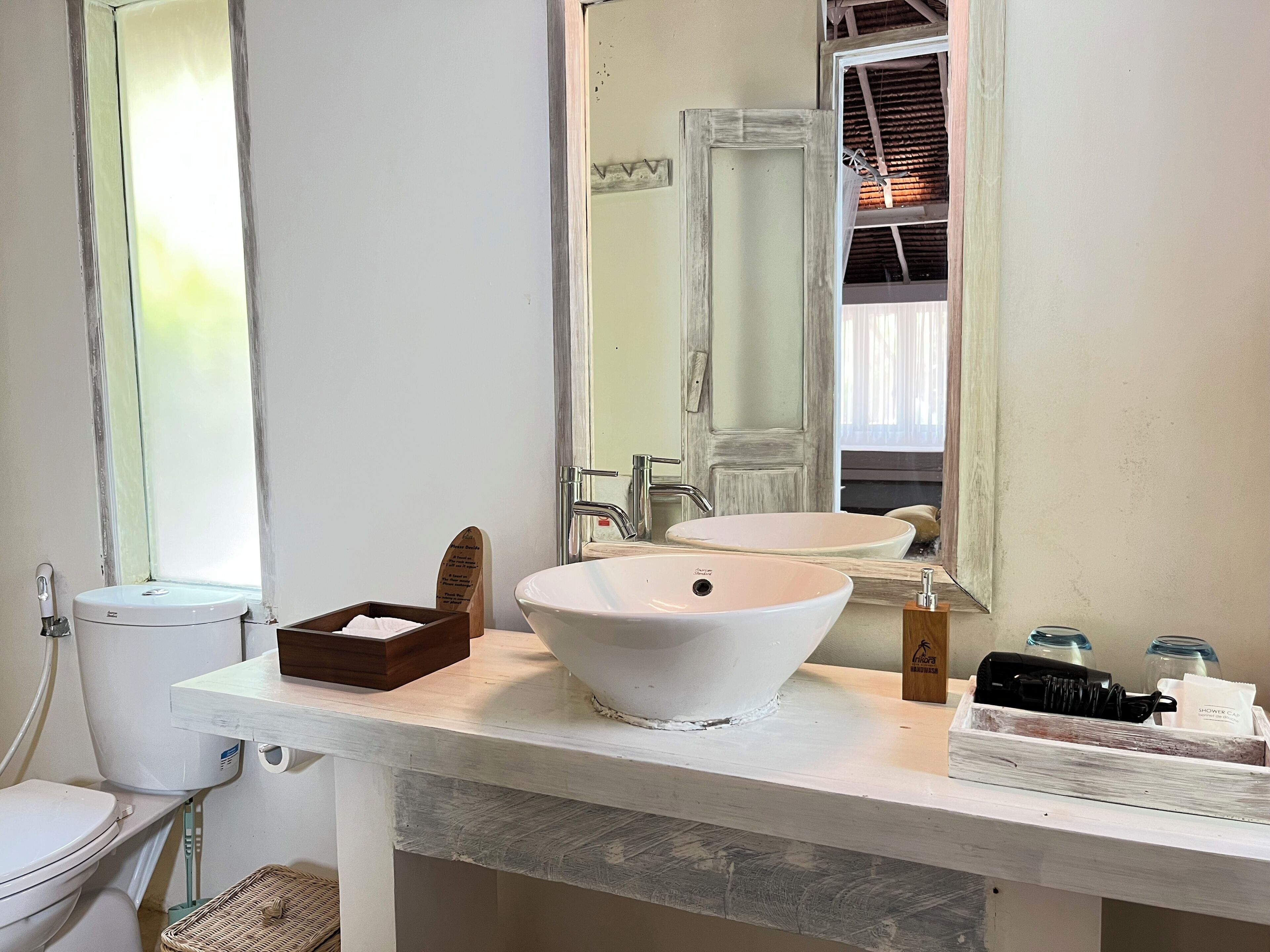 A bathroom with a white sink, a mirror, and a toilet.