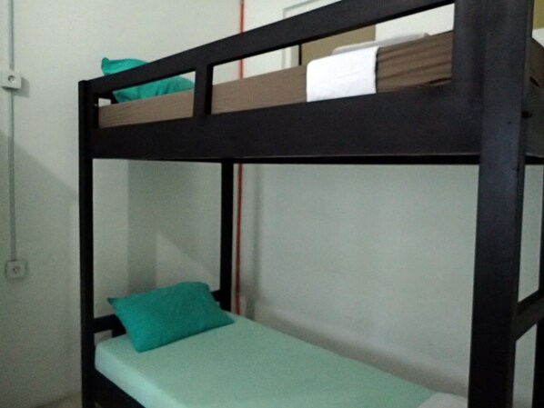 A bunk bed with a teal pillow and a white sheet. - Palma Bed & Breakfast - Hostel (Jimbaran)