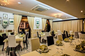 Ein Restaurant mit gedeckten Tischen, das ein modernes Interieur mit Deckenventilator und stimmungsvoller Beleuchtung zeigt.