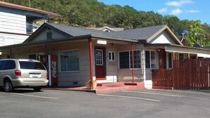 A single-story building with a red door and a Coca-Cola sign, parked in front. - Roseburg Inn (Roseburg)