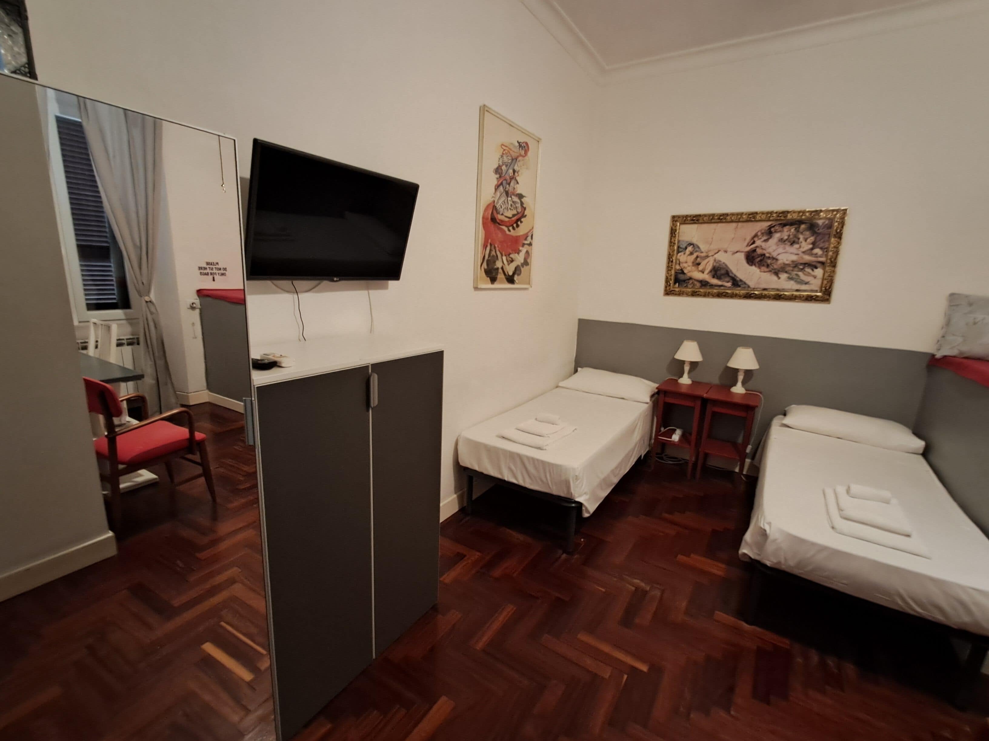 Een hotelkamer met een bed, een bureau, een televisie en een stoel.