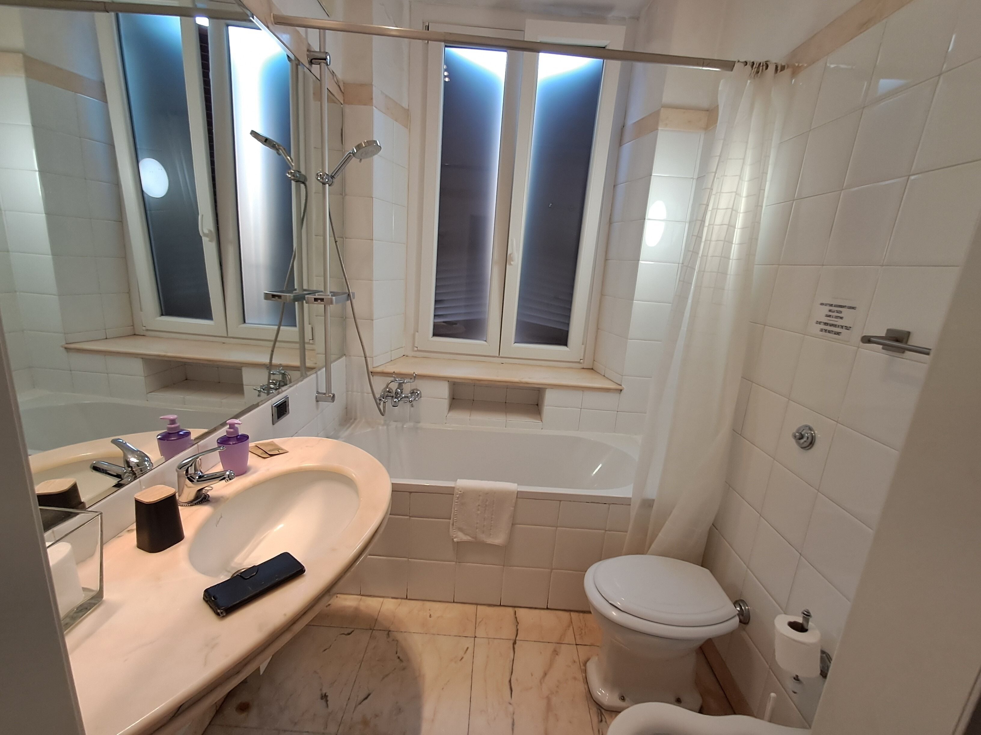 A bathroom with a bathtub, toilet, and sink.