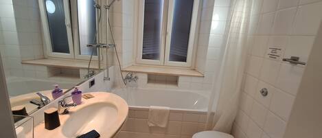 A bathroom with a bathtub, toilet, and sink.