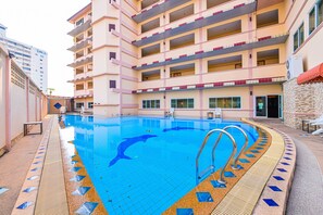 A swimming pool with a dolphin design, surrounded by a building with multiple balconies and a tiled deck. - AA Pattaya Ville (Pattaya)