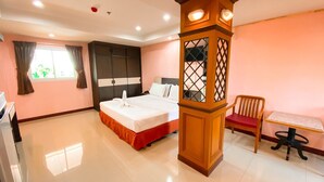 Ein Hotelzimmer mit Bett, Schreibtisch, Stuhl und einer dekorativen Holzsäule.