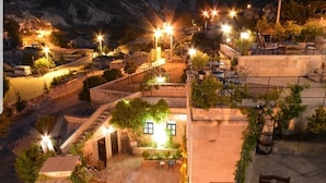 Una terraza en la azotea con mobiliario exterior, una escalera y vistas del paisaje circundante.