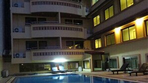 A multi-story hotel with a swimming pool.