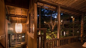 A wooden deck with a bamboo ceiling, surrounded by trees and a wooden fence. - Kurokawa Onsen Oyado Noshiyu (Minamioguni)