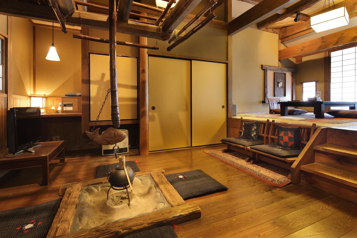Ein traditioneller japanischer Raum mit Tatami-Boden, einem niedrigen Tisch mit Wasserkocher und einer Schiebetür.