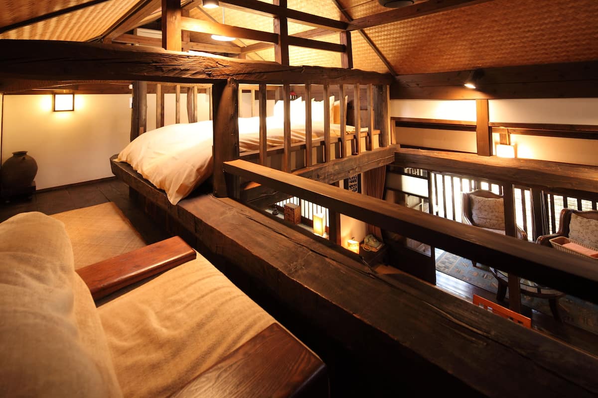 Ein rustikales Cabin-Interieur mit einem Holzbett, einer Bank und einem kleinen Tisch.