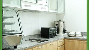 Una cocina equipada con microondas, cafetera y tostadora.