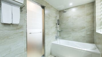 Un baño moderno con ducha envuelta en vidrio, una bañera independiente y un revestimiento de azulejos.