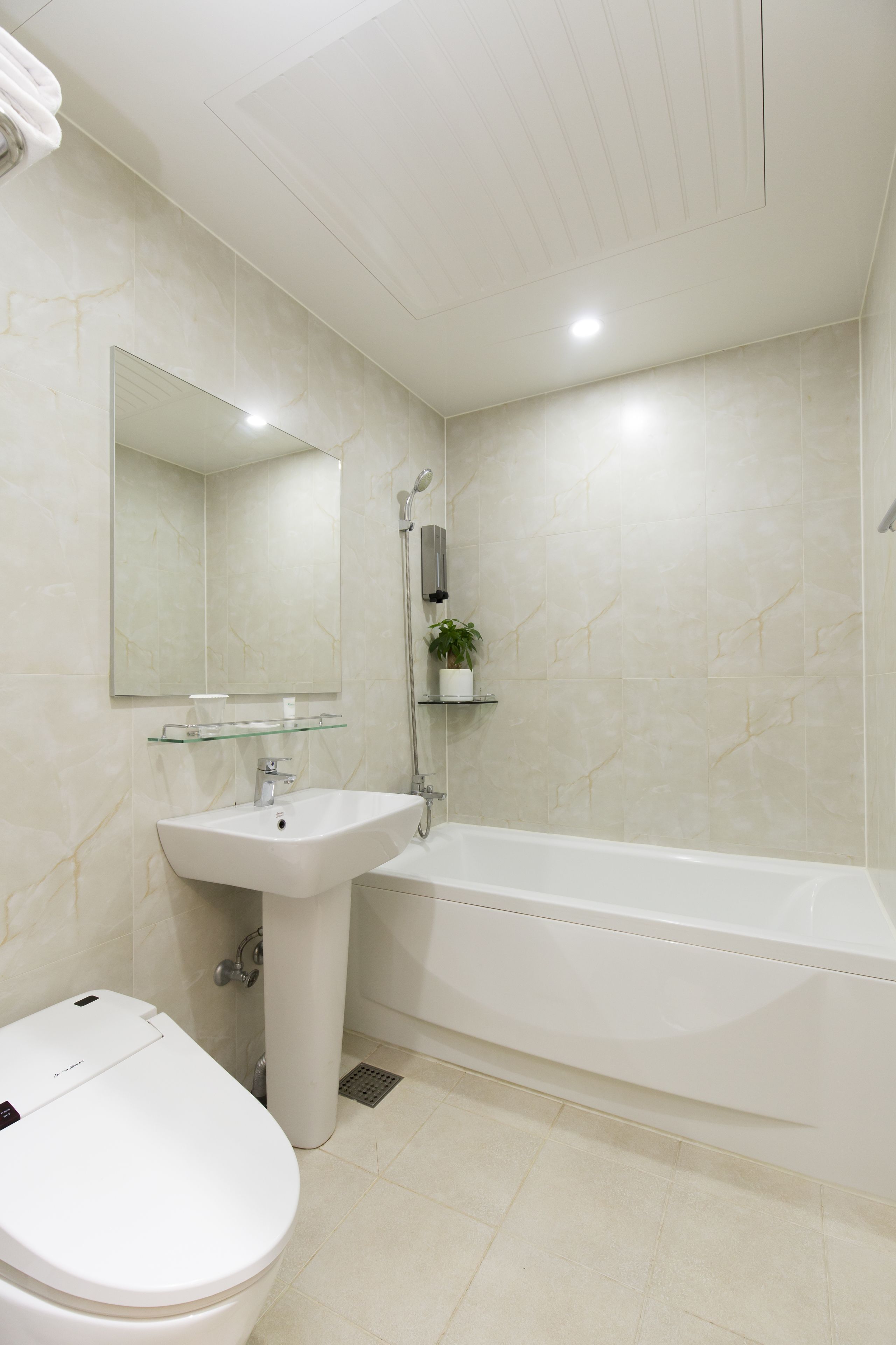 A bathroom with a toilet, sink, and bathtub.