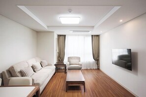 Relax in this stylish living room with a comfortable sofa, wooden coffee table, and large window.