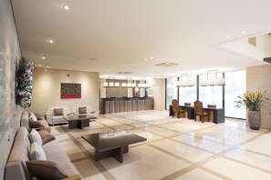 Relax in our spacious lobby, featuring a reception desk, comfortable seating areas, and a natural ambiance.