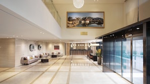A spacious lobby with a reception desk, seating area, and a large painting on the wall. - Crown Harbor Hotel Busan (Busan)