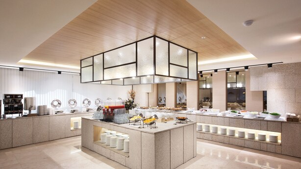 A modern kitchen with a central island, built-in appliances, and a variety of food items displayed on the counter. - Crown Harbor Hotel Busan (Busan)
