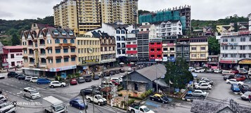 Una vivace strada cittadina con diversi edifici, tra cui un albergo con il cartello che riporta "Hotel Sentosa".