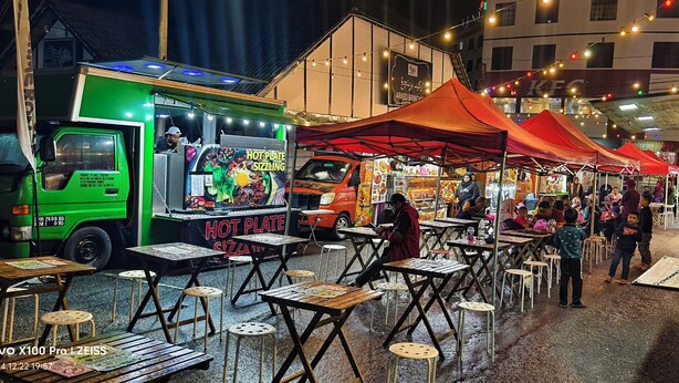 Un mercado de alimentos con varios puestos y mesas.
