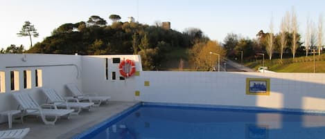 Alberca al aire libre y camastros
