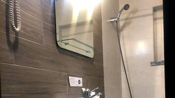 Un baño con lavamanos, espejo y ducha.
