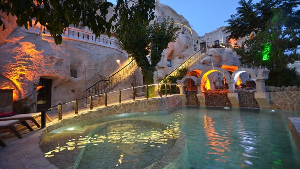 A pool area with a stone wall, a staircase, and a railing. - Gamirasu Cave Hotel - Special Class (Ürgüp)