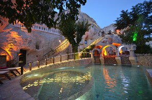 A pool area with a stone wall, a staircase, and a railing. - Gamirasu Cave Hotel - Special Class (Ürgüp)