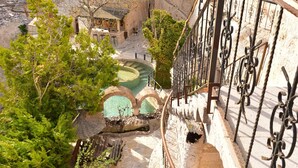 A courtyard with a stone staircase, a pool, and a view of the surrounding buildings. - Gamirasu Cave Hotel - Special Class (Ürgüp)